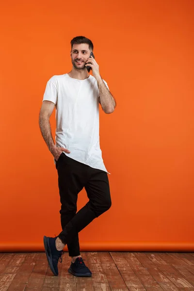 Sade Beyaz Tişört Giyen Gülümseyen Cep Telefonuyla Konuşan Genç Sakallı — Stok fotoğraf