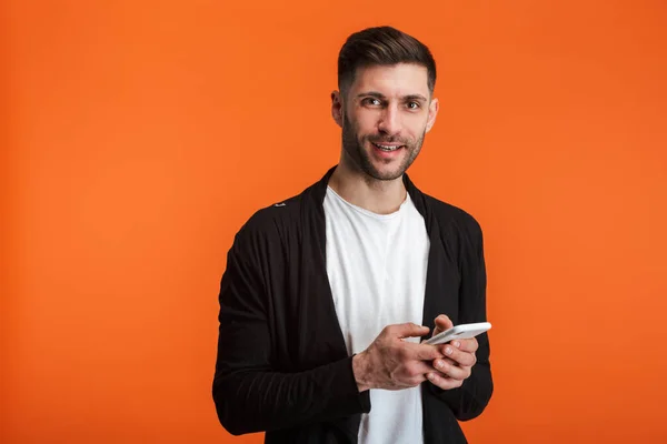 Imagen Joven Barbudo Vestido Con Ropa Básica Sonriendo Sosteniendo Teléfono —  Fotos de Stock