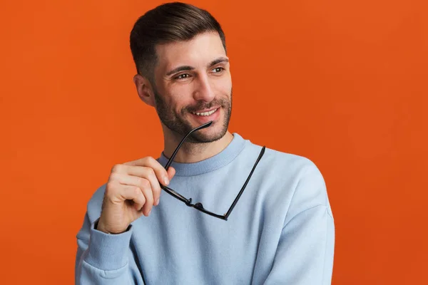 Imagen Joven Barbudo Guapo Usando Suéter Sosteniendo Sus Anteojos Aislados —  Fotos de Stock