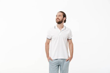 İyimser, mutlu, yakışıklı, sakallı bir adamın beyaz duvar arkasında yalnız poz vermesi..