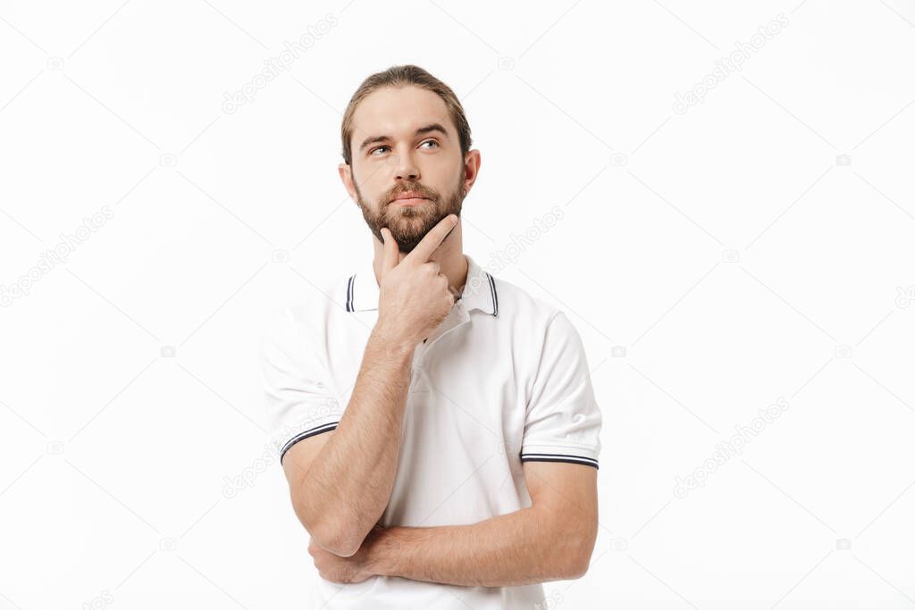 Image of a concentrated thinking young handsome bearded man posing isolated over white wall background.