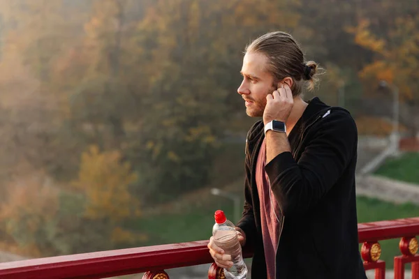 Fešák Mladý Fit Sportovec Poslech Hudby Bezdrátovými Sluchátky Mostě Drží — Stock fotografie