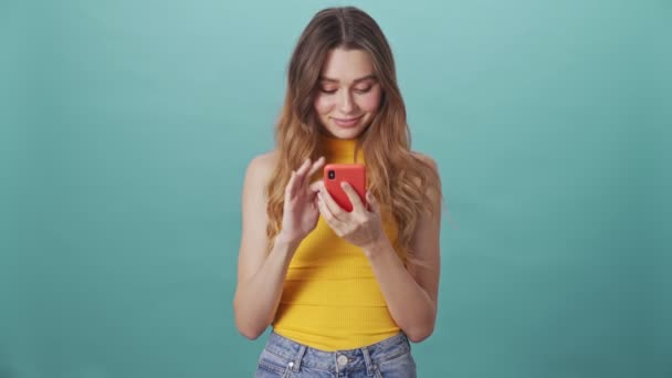 Jovem Alegre Usando Rolando Smartphone Isolado Fundo Azul — Vídeo de Stock