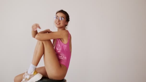 Gülümseyen Şık Bikinili Gözlüklü Bir Kadın Sandalyede Oturuyor Gri Arka — Stok video