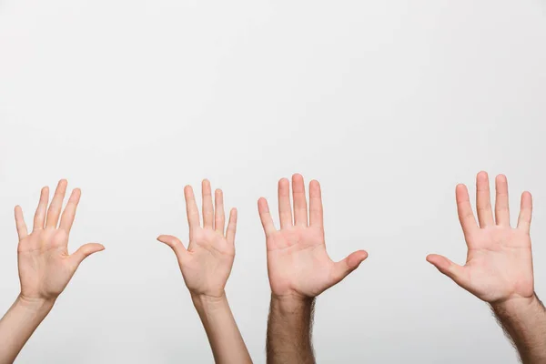 stock image Closeup image of a man's and woman's raised hands isolated over white wall background.
