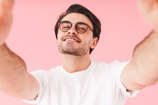 Obraz Młodego Radosnego Mężczyzny Okularach Uśmiechniętych Robiącego Selfie Różowym Tle — Zdjęcie stockowe