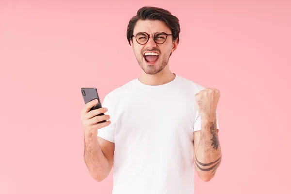 Imagem Jovem Homem Animado Vestindo Óculos Segurando Celular Mostrando Gesto — Fotografia de Stock