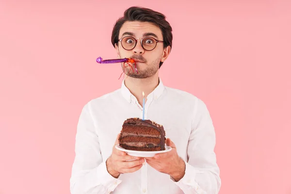 ピンクの背景の上に隔離されたキャンドルとチョコレートケーキを保持眼鏡を身に着けている白人驚きの男のイメージ — ストック写真