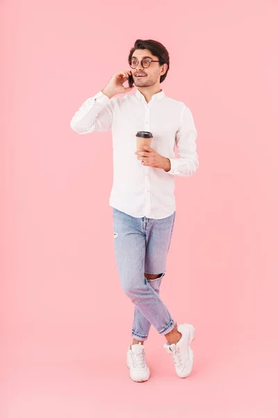 수염없는 남자가 안경을 커피를 마시고 고립된 핸드폰으로 이야기하는 — 스톡 사진