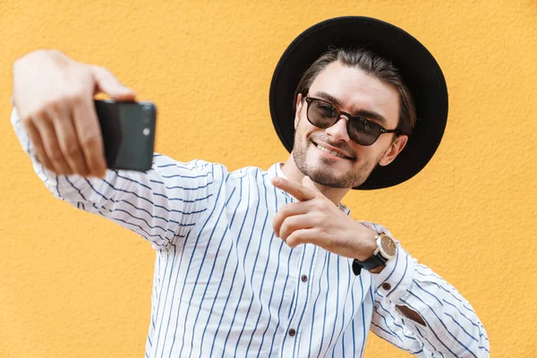 Imagen Joven Sonriente Con Gafas Sol Sombrero Negro Tomando Selfie — Foto de Stock