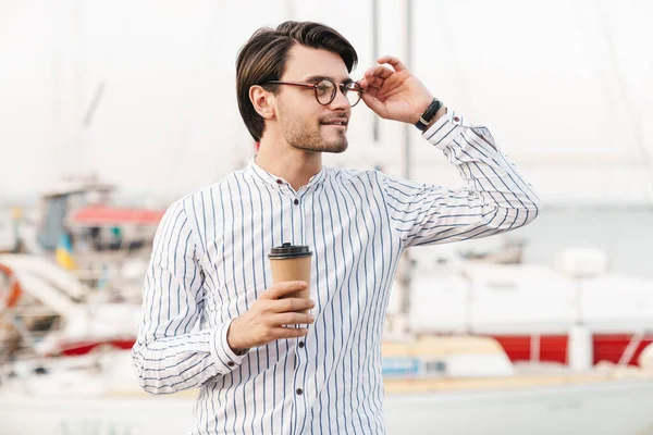 Photo Successful Pleased Man Wearing Eyeglasses Standing Drinking Coffee Paper — Stock Photo, Image