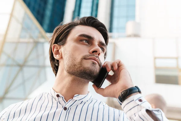 Foto Allvarlig Ung Man Randig Skjorta Talar Mobiltelefon Och Tittar — Stockfoto