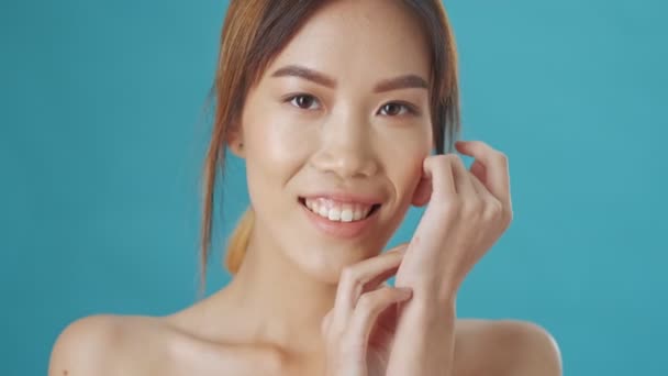 Vacker Asiatisk Kvinna Poserar Till Kameran Isolerad Över Blå Vägg — Stockvideo