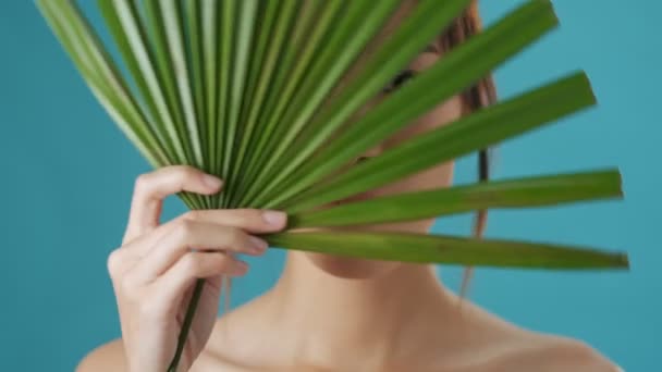 Emotional Young Asian Woman Holding Green Plant Leaf While Covering — Stock Video