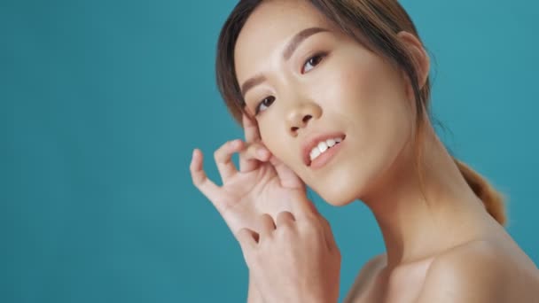 Una Hermosa Joven Asiática Posando Cámara Sonriendo Sobre Fondo Azul — Vídeo de stock