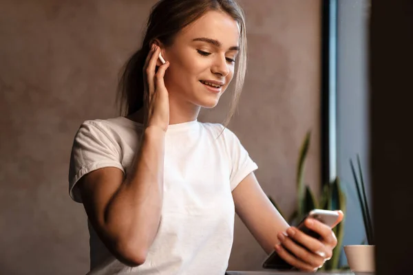 Foto Mulher Agradável Feliz Usando Fones Ouvido Celular Enquanto Sentado — Fotografia de Stock