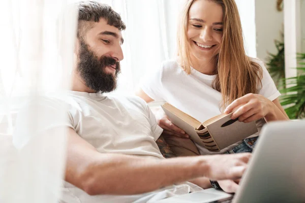 Imagen Una Pareja Caucásica Sonriente Usando Portátil Leyendo Libro Mientras — Foto de Stock