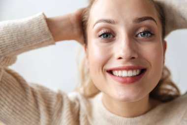 Evde poz veren mutlu, iyimser genç bir kadının görüntüsü..