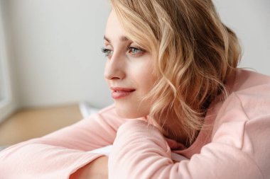 Evde poz veren mutlu, iyimser genç bir kadının görüntüsü..