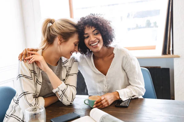 Två Glada Unga Kvinnor Vänner Sitter Caféet Dricker Kaffe Kramas — Stockfoto