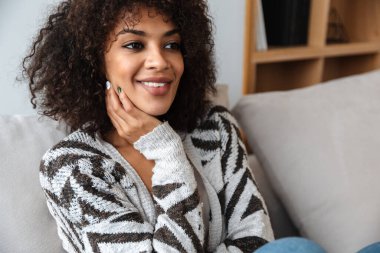 Evdeki neşeli, mutlu, güzel, Afrikalı bir kadının görüntüsü..