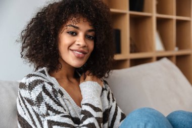 Evdeki neşeli, mutlu, güzel, Afrikalı bir kadının görüntüsü..