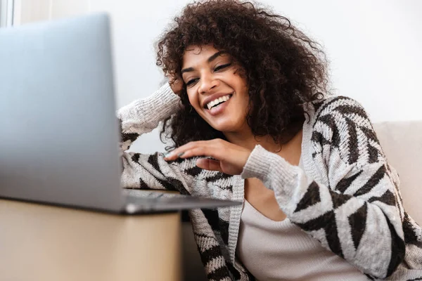 Evde Dizüstü Bilgisayar Kullanan Güzel Pozitif Gülümseyen Bir Afrikalı Kadın — Stok fotoğraf