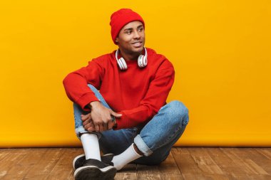 Çekici, kendine güveni tam genç bir Afrikalı adamın portresi sarı arka planda bir yerde oturuyor.