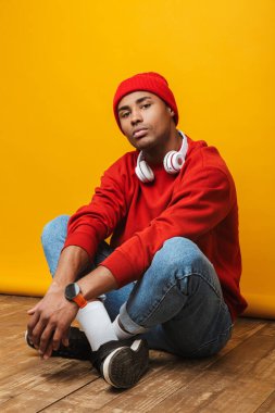 Çekici, kendine güveni tam genç bir Afrikalı adamın portresi sarı arka planda bir yerde oturuyor.