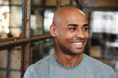 Çekici, kel, Afro-Amerikan bir adamın gülümseyişi ve içeri bakışıydı.