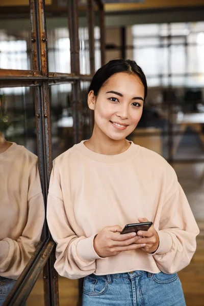 Bild Ung Vacker Asiatisk Kvinna Ler Och Håller Mobiltelefon Medan — Stockfoto