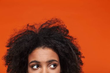 Kızıl arka planda izole edilmiş genç bir Afrikalı kadının yarım portresini kapat.