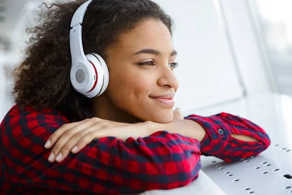 年轻的非洲裔美国女人的画像 身穿格子花衬衫 微笑着 用耳机听音乐 — 图库照片