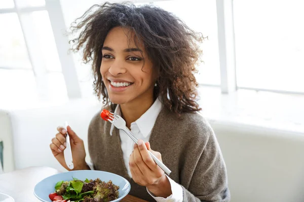 カフェでランチをしながらサラダを食べる若い美しいアフリカ系アメリカ人女性の肖像 — ストック写真