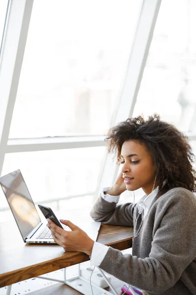 Portré Fiatal Gyönyörű Afro Amerikai Segítségével Laptop Mobiltelefon Miközben Ablak — Stock Fotó