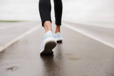 Stadyumdaki Afrikalı kadın spor ayakkabılarını yakından izle.