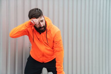 Çekici genç sporcu dışarıda koştuktan sonra dinleniyor.