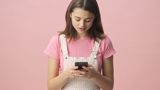 Calma Mujer Morena Bonita Overoles Usando Teléfono Inteligente Sobre Fondo — Vídeo de stock