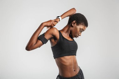 Beyaz arka planda izole bir şekilde çalışırken spor yapan Afrikalı Amerikalı spor kadını görüntüsü