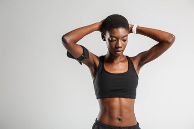 Beyaz arka planda izole bir şekilde çalışırken spor yapan Afrikalı Amerikalı spor kadını görüntüsü