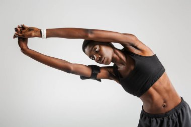 Beyaz arka planda izole bir şekilde çalışırken spor yapan Afrikalı Amerikalı spor kadını görüntüsü