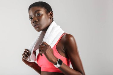 Beyaz arka planda izole edilmiş havluyla poz veren Afrikalı Amerikalı sporcu