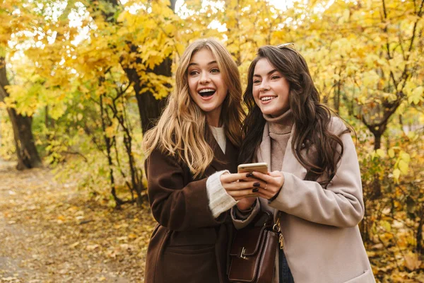 Duas Jovens Meninas Bonitas Alegres Vestindo Casacos Andando Juntas Floresta — Fotografia de Stock