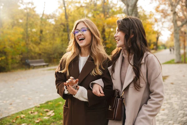 Duas Jovens Meninas Bonitas Alegres Vestindo Casacos Andando Juntas Parque — Fotografia de Stock