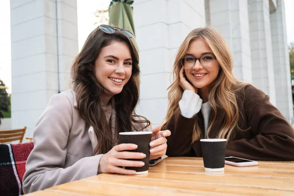 Две Весёлые Привлекательные Подружки Сидят Кафе Свежем Воздухе Пьют Кофе — стоковое фото