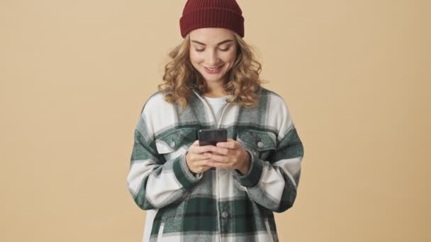 Sorrindo Mulher Bonita Chapéu Malha Camisa Usando Smartphone Sobre Fundo — Vídeo de Stock