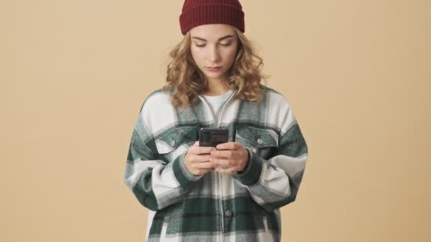 Calm Pretty Woman Knit Hat Shirt Using Smartphone Becoming Surprised — Stock Video