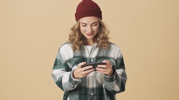 Mujer Bonita Alegre Sombrero Punto Camisa Jugando Teléfono Inteligente Regocijándose — Vídeo de stock