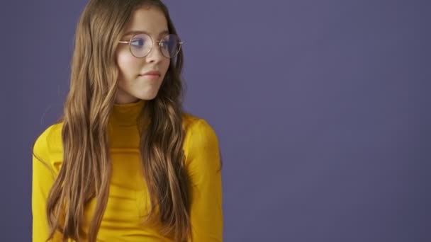 一个快乐而积极的少女正看着旁边 然后伸出一只大拇指 孤零零地站在工作室的紫色背景上 — 图库视频影像