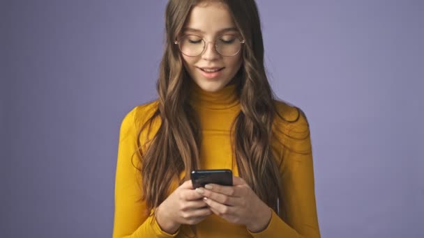 Una Adolescente Sonriente Positiva Está Utilizando Teléfono Inteligente Pie Aislado — Vídeo de stock